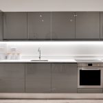 Modern kitchen with glossy grey cabinets and oven.