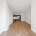 Minimalist kitchen with wooden floor and brown cabinets.