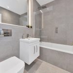 Modern grey bathroom with bathtub and plants