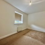 Empty room with carpet and single window.