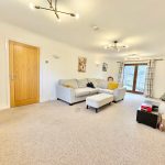 Modern living room with grey sofa and TV.