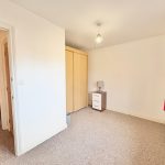 Empty bedroom with wardrobe and bedside lamp.