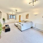 Spacious living room with sofa and wall art.
