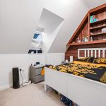 Cosy attic bedroom with yellow patterned bed.