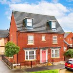 Two-storey red brick house with pink door.