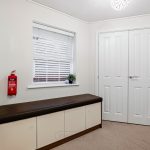 Hallway with bench, window, and white doors.