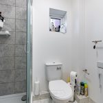 Modern bathroom with shower, toilet and sink.