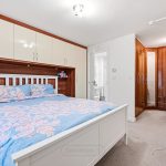 Modern bedroom with built-in wardrobes and desk.