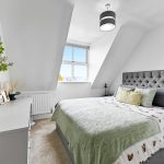 Modern bedroom with double bed and skylight window.