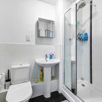 Modern bathroom with shower, sink, and toilet.