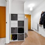 Organised hallway with coat rack and storage cubes.