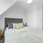 Modern bedroom with grey headboard and bedside table