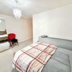 Spacious bedroom with bed and wardrobe.