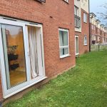 Brick building with patio door and grassy path