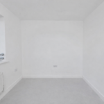 Empty white room with window and radiator