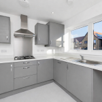 Modern grey kitchen with large windows and cooker.