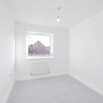 Empty white room with window view outside.