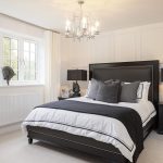 Elegant bedroom with large window and modern decor.