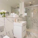 Modern bathroom with marble decor and walk-in shower.