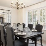 Elegant dining room with large mirror and chandelier.