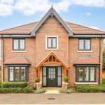 Modern brick house with garden and driveway.