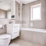 Modern bathroom with bath, sink, and toilet.