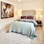 Modern bedroom with abstract artwork and cosy decor.