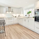 Modern white kitchen with breakfast bar stools.