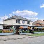 Pub exterior with flower decorations and signage