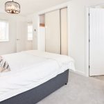 Bright modern bedroom with ensuite bathroom and cosy chair.
