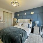 Modern bedroom with blue accents and stylish decor.