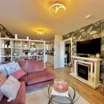 Modern living room with pink sofa and fireplace.