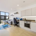 Modern bright studio apartment with kitchen and living area.