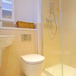 Modern bathroom with shower, sink, and toilet.