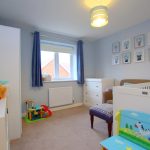 Bright children's room with toys and cot.