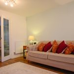 Modern living room with beige sofa and cushions.