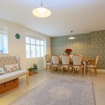 Elegant dining room with floral wallpaper and cosy decor.