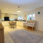 Spacious modern kitchen with dining area and sofa.