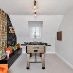 Modern games room with foosball table and seating.