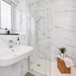 Modern bathroom with marble walls and shower.