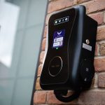 Electric vehicle charging point on brick wall.
