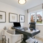 Modern home office with artwork and window view.