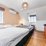 Modern bedroom with twin beds and wooden furniture.