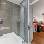 Bathroom with shower and adjoining colourful bedroom.