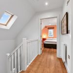 Hallway leading to cosy bedroom with skylight.