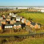 Aerial view of residential houses and football field.