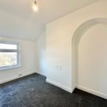 Empty white room with window and archway