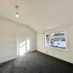 Bright empty room with carpet and large window.