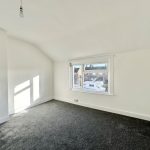 Empty room with window and grey carpet