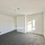 Empty room with grey carpet and white walls.